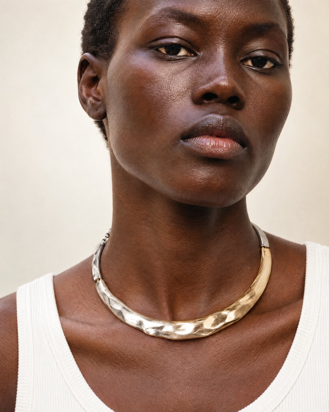 Retrato de mulher com gargantilha rígida martelada em prata e dourado